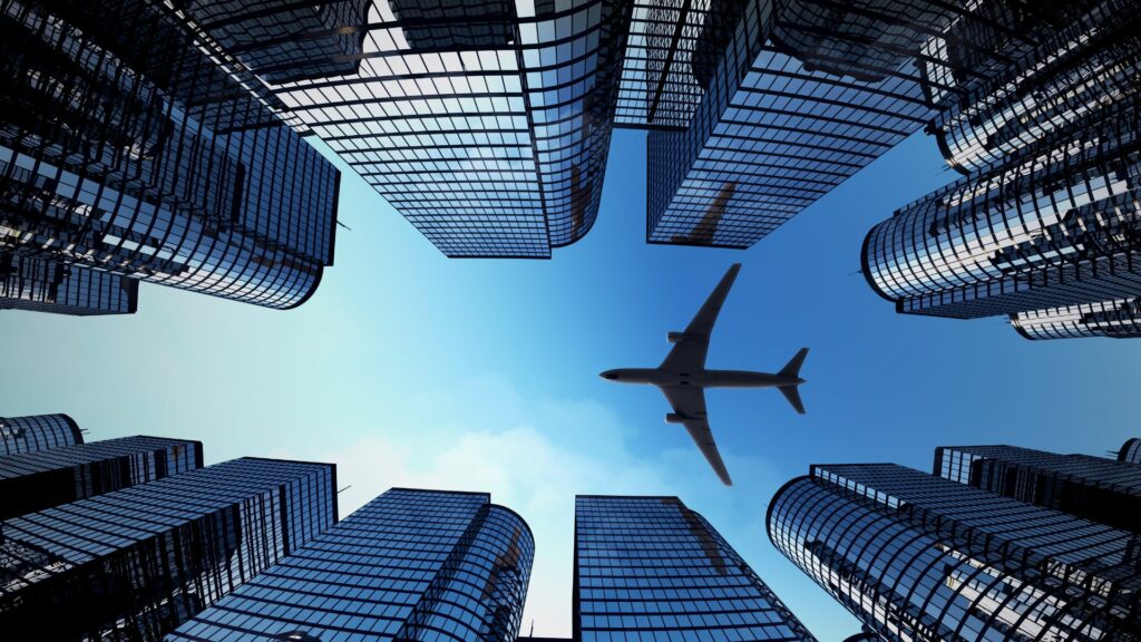 An airplane flying in the sky in the middle of city buildings